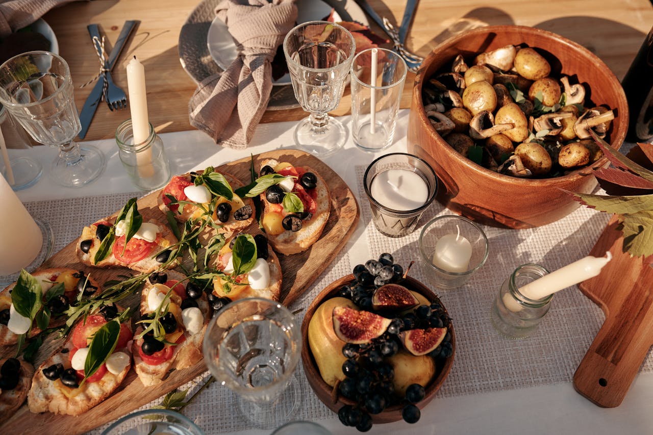 A beautifully set outdoor dining table featuring an array of fresh vegan dishes under sunlight.