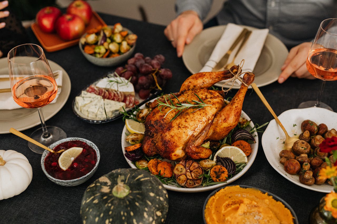 A delicious Thanksgiving dinner spread with roasted chicken, sides, and wine.